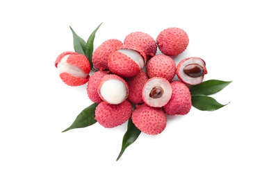 Pile of fresh ripe lychees with green leaves on white background, top view