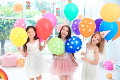 Cute girls with balloons at birthday party indoors