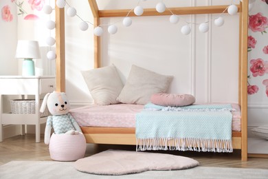 Photo of Stylish child room interior with wooden house bed