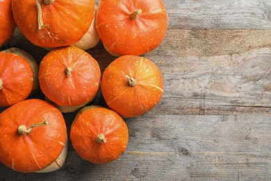 Orange pumpkins on wooden background, flat lay composition with space for text. Autumn holidays