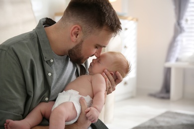 Photo of Father with his newborn son at home