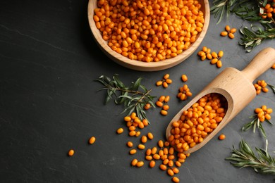 Fresh ripe sea buckthorn on black table, flat lay