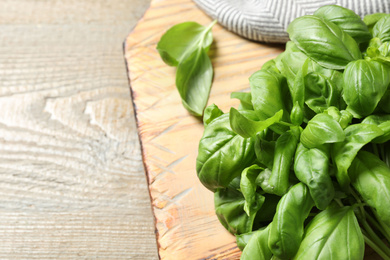 Photo of Fresh basil on wooden table, closeup. Space for text