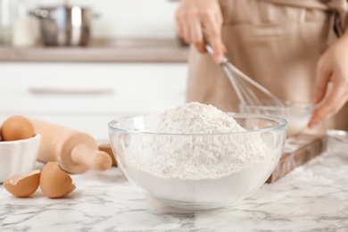Photo of Bowl with flour and woman on background