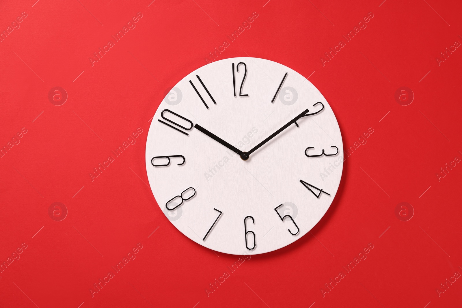 Photo of Modern clock on red background, top view