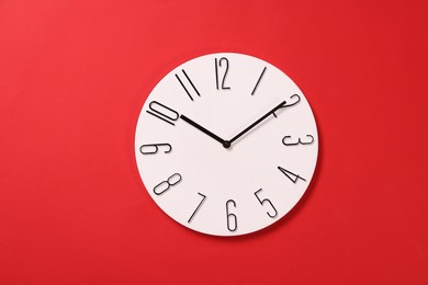 Photo of Modern clock on red background, top view