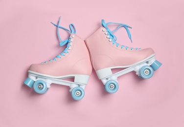 Photo of Pair of stylish quad roller skates on color background, top view