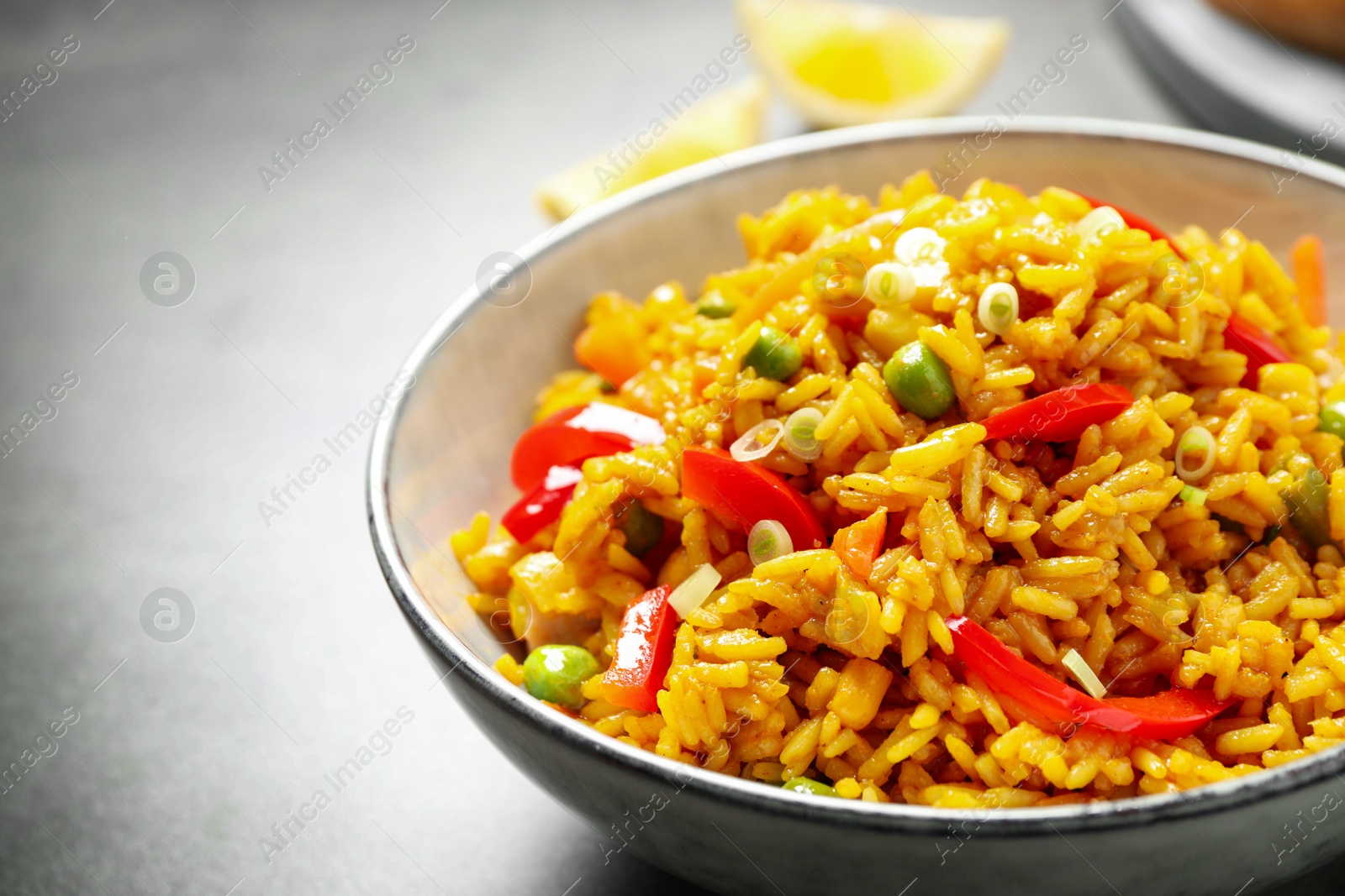 Photo of Delicious rice pilaf with vegetables in bowl on table, closeup