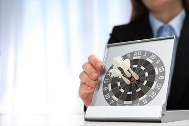 Photo of Woman with darts at table. Business trainer concept