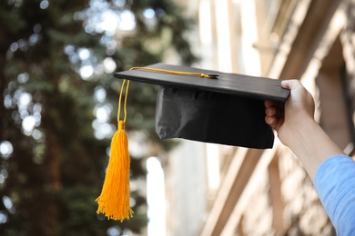 Photo of Student with graduation hat outdoors on sunny day, closeup