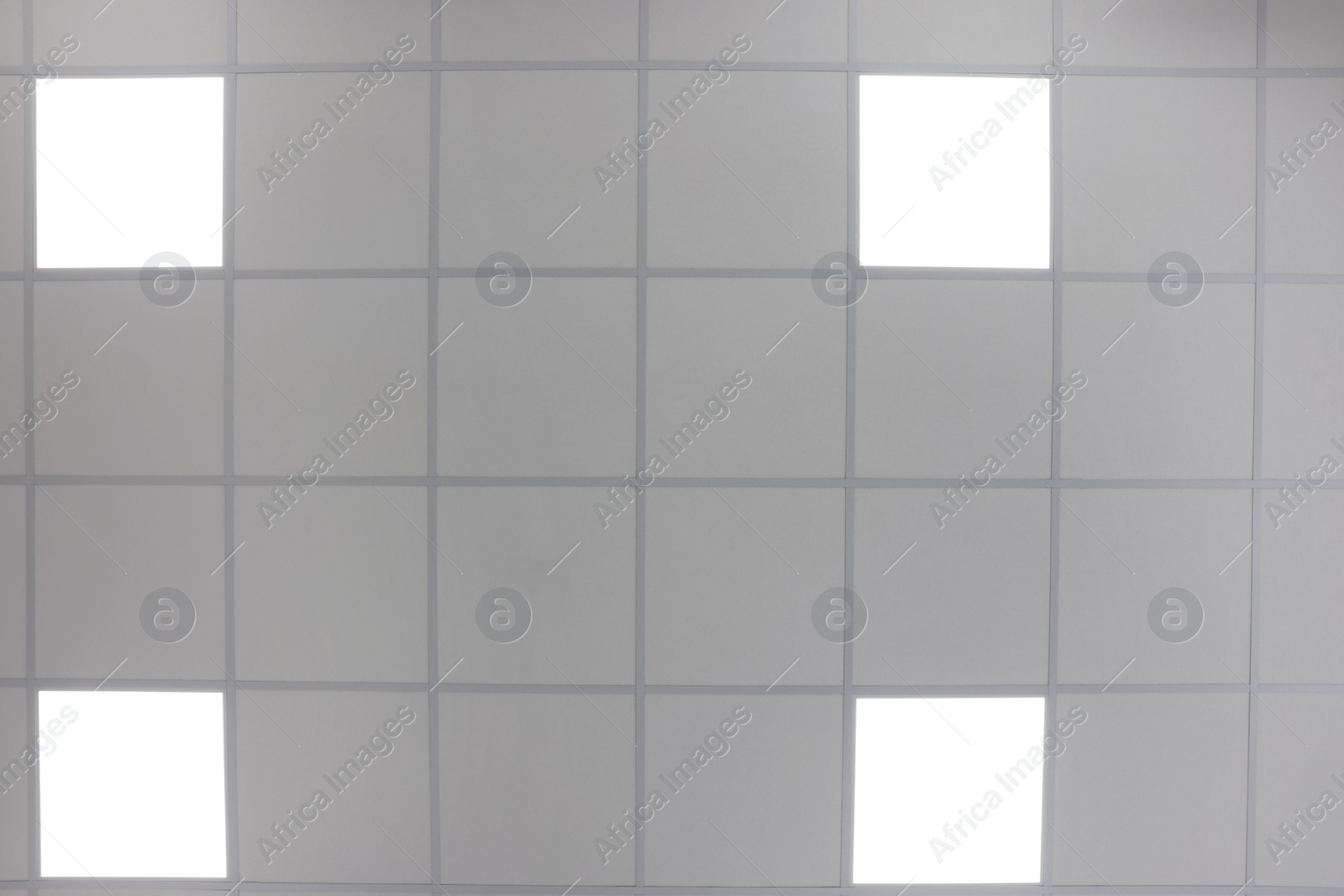 Photo of White ceiling with PVC tiles and lighting indoors, bottom view