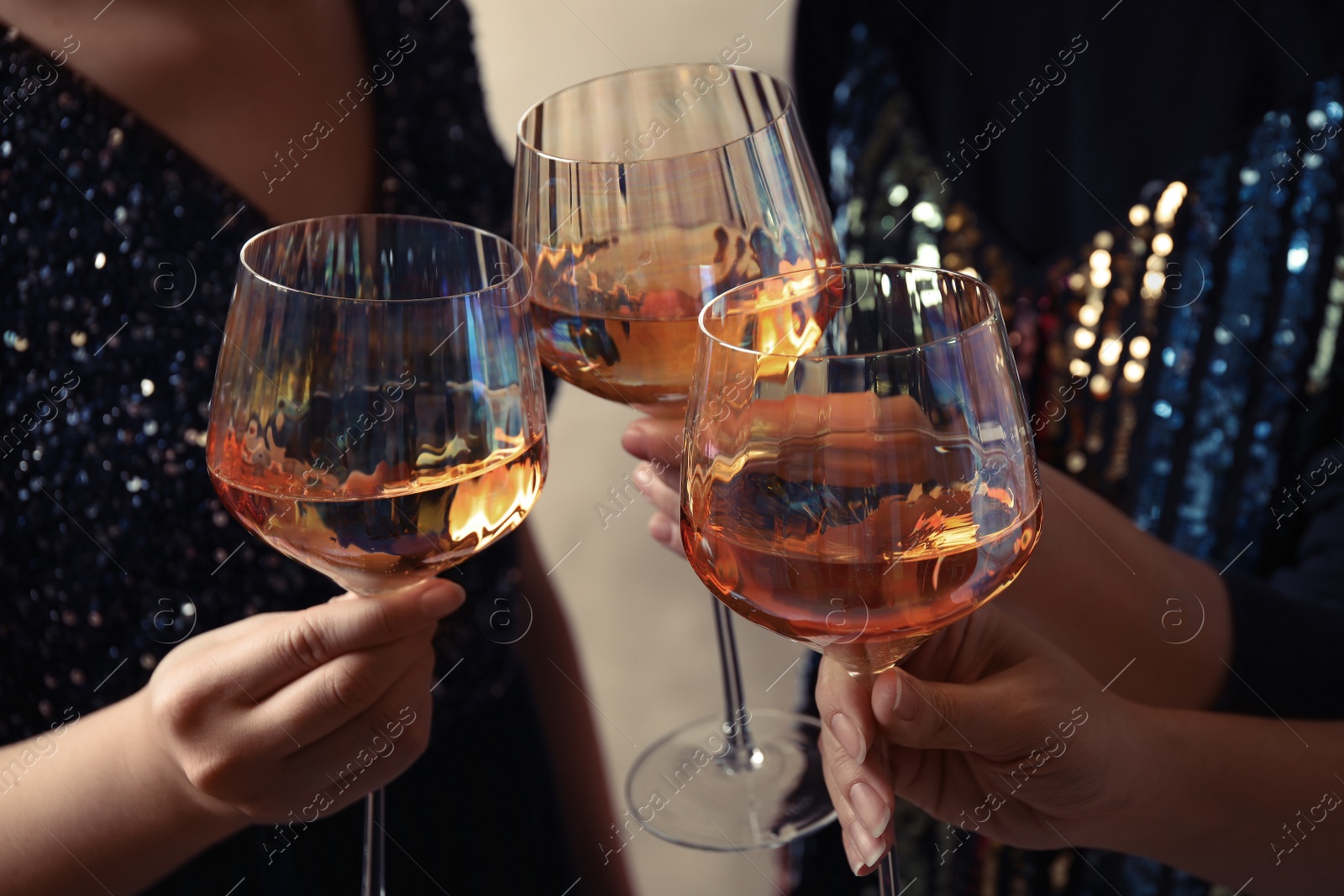 Photo of Women clinking glasses with white wine, closeup