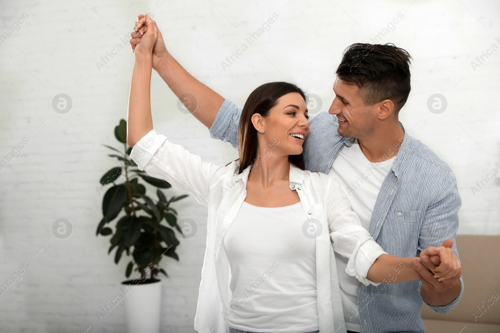 Photo of Happy young couple dancing together at home