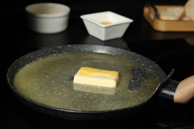 Photo of Melting butter in frying pan on cooktop