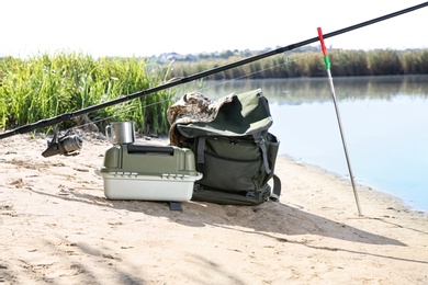 Rod and fishing essentials at riverside on sunny day