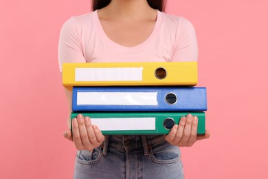 Woman with folders on pink background, closeup