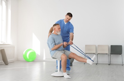 Photo of Professional physiotherapist working with senior patient in rehabilitation center