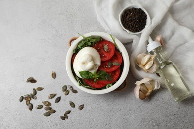 Flat lay composition with delicious burrata cheese and tomatoes on light grey table