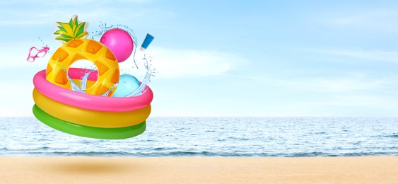 Image of Beach accessories flying over sandy beach. Banner design with space for text