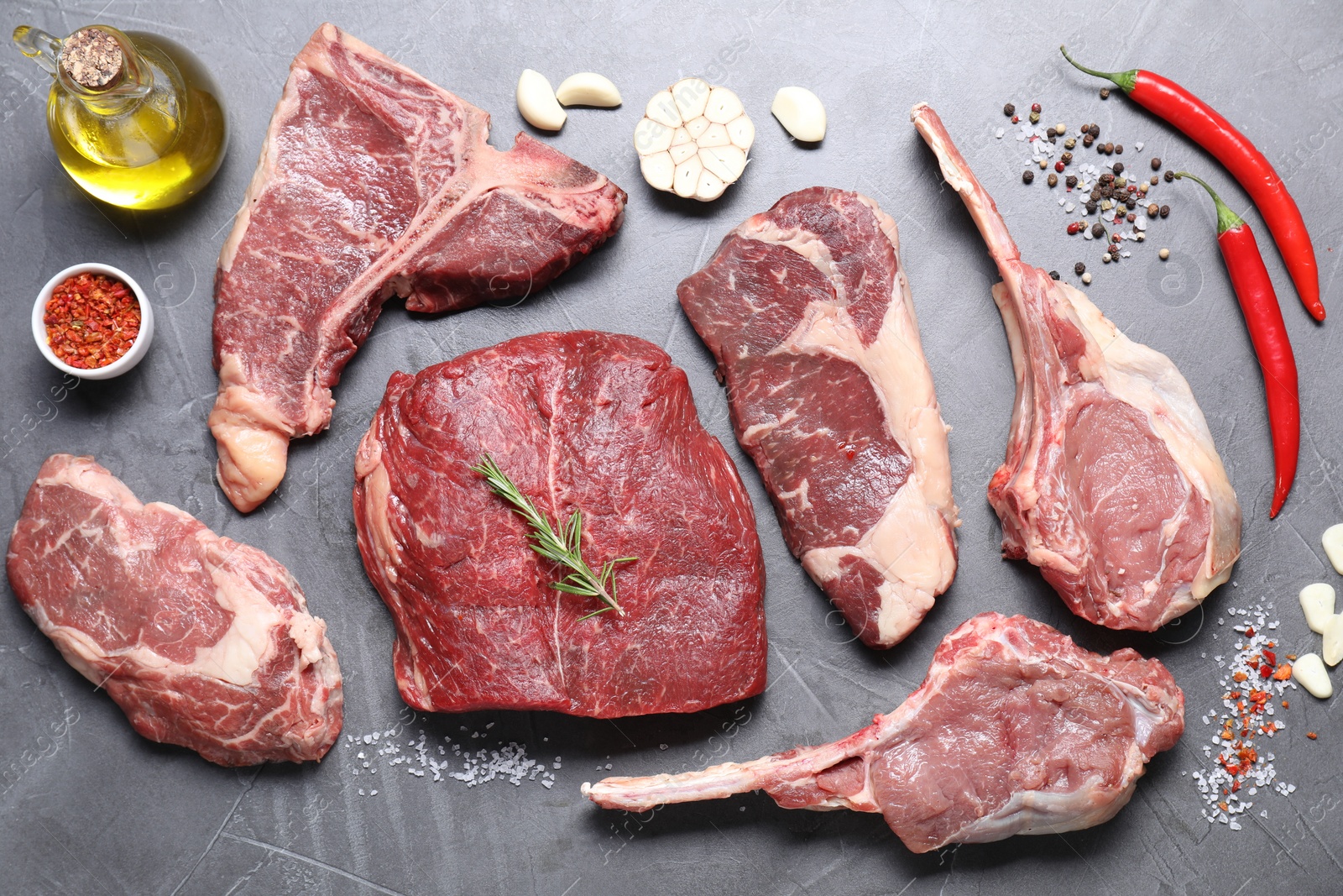 Photo of Fresh raw beef cut and spices on light grey textured table, flat lay