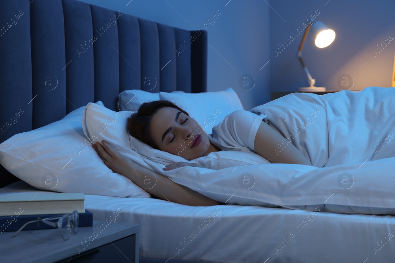 Photo of Beautiful young woman sleeping in bed at night