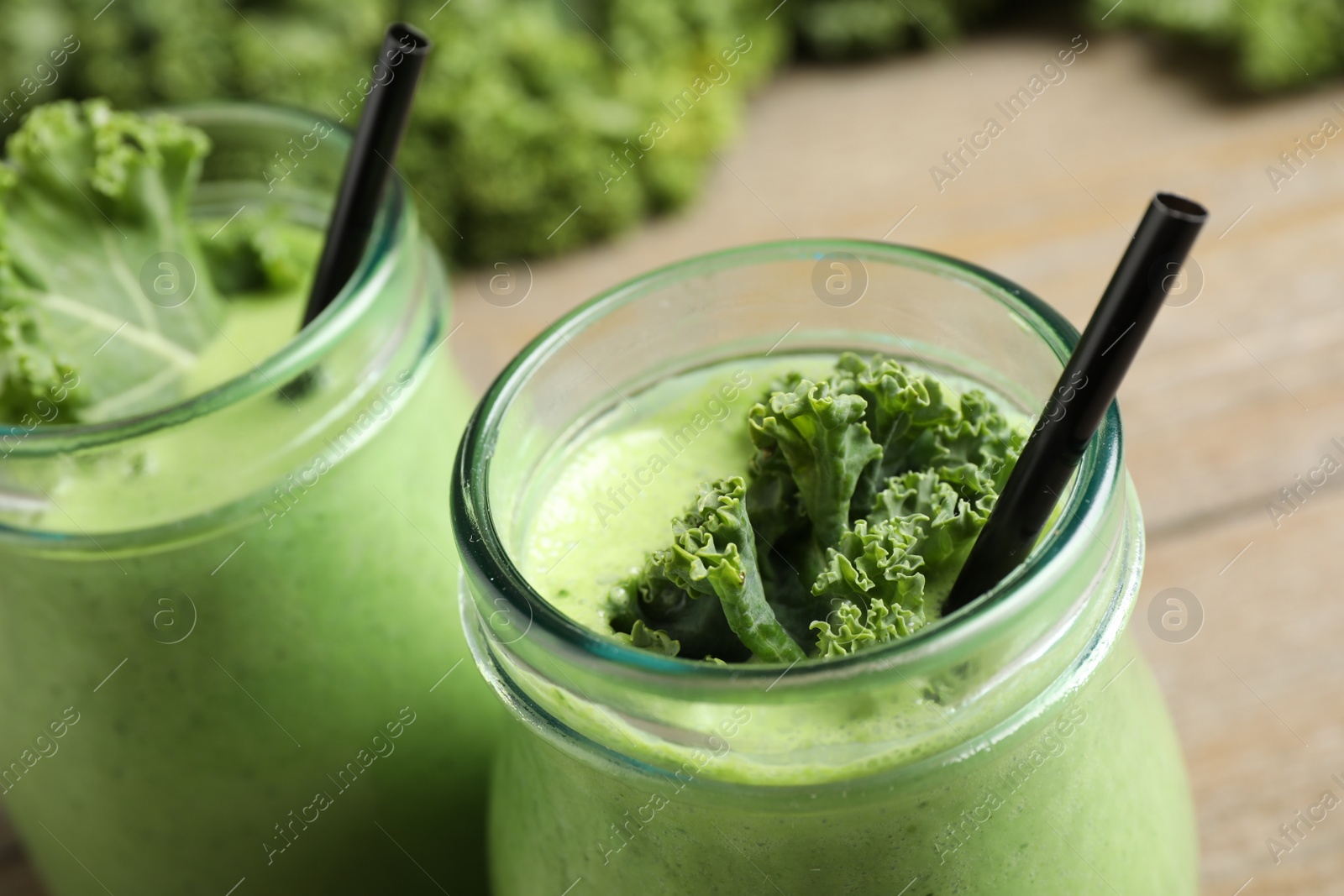 Photo of Tasty fresh kale smoothie on table, closeup