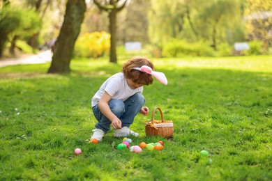 Easter celebration. Cute little boy hunting eggs outdoors