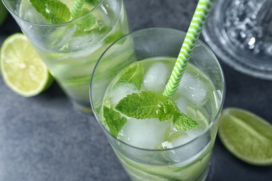 Photo of Glasses of natural lemonade with lime on table, closeup