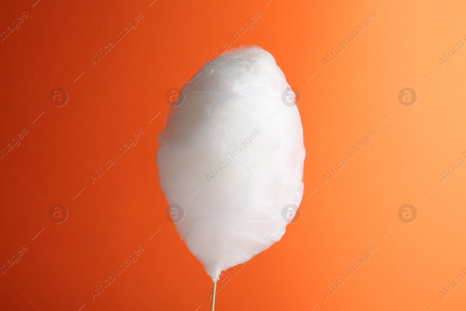 Photo of One sweet cotton candy on orange background