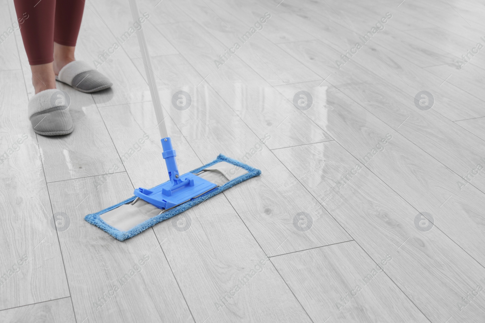 Photo of Woman mopping floor indoors, closeup. Space for text