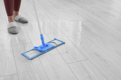 Photo of Woman mopping floor indoors, closeup. Space for text