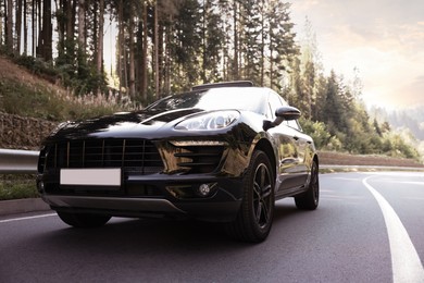 Photo of Modern black car on asphalt road outdoors