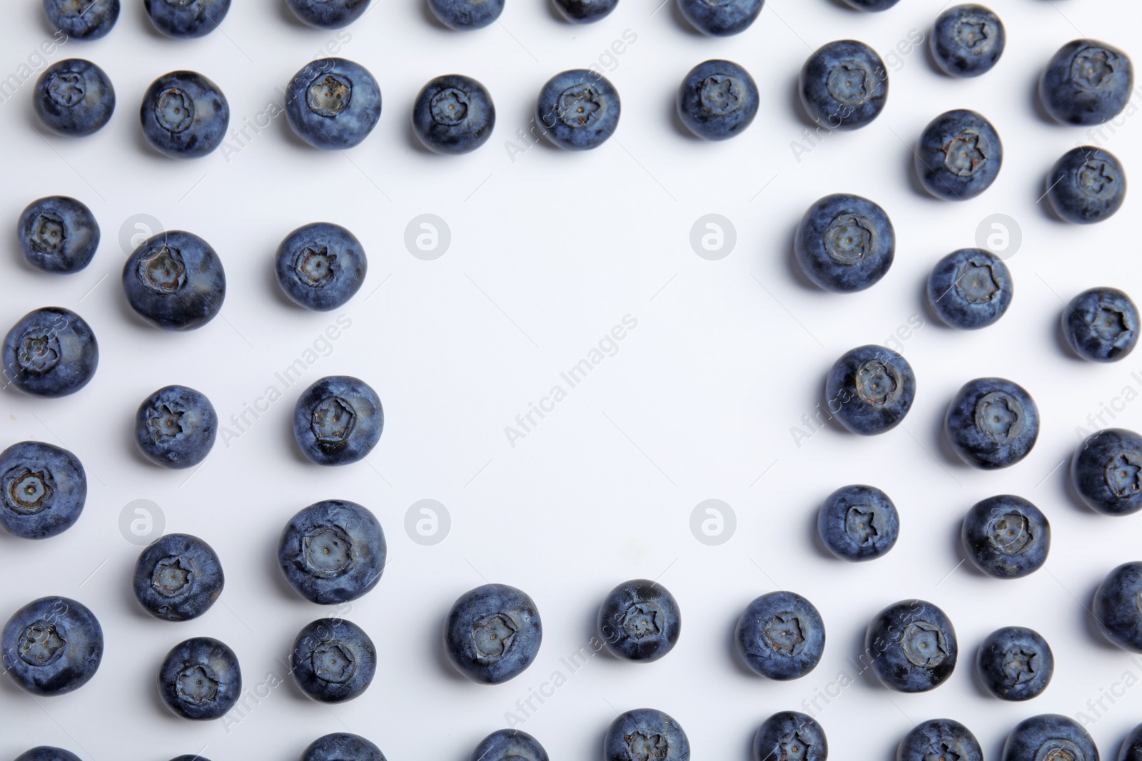 Photo of Frame of ripe blueberries on white background, flat lay with space for text