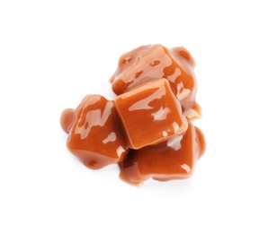 Delicious candies with caramel sauce on white background, top view