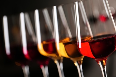 Photo of Row of glasses with different wines on blurred background, closeup
