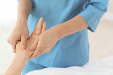 Woman receiving hand massage in wellness center, closeup