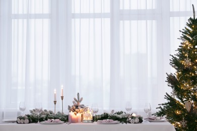 Photo of Beautiful festive table setting with Christmas decor in room