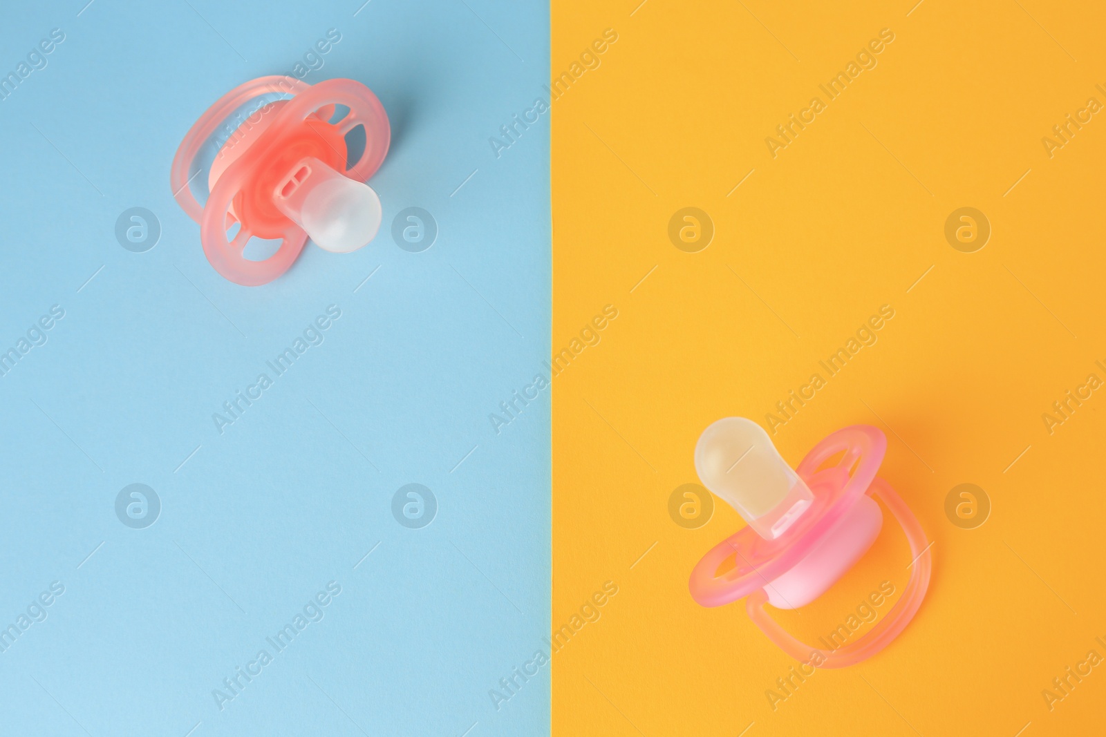 Photo of New baby pacifiers on color background, flat lay