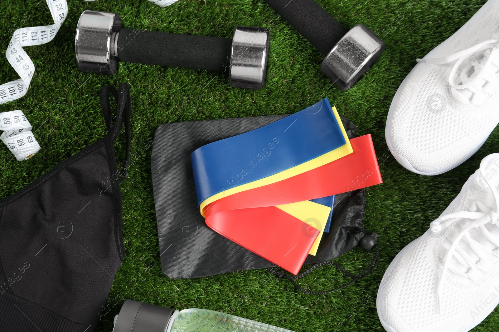 Photo of Flat lay composition with fitness elastic bands on green grass