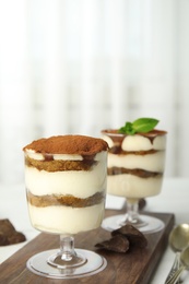 Photo of Composition with two glasses of tiramisu cake and chocolate on table