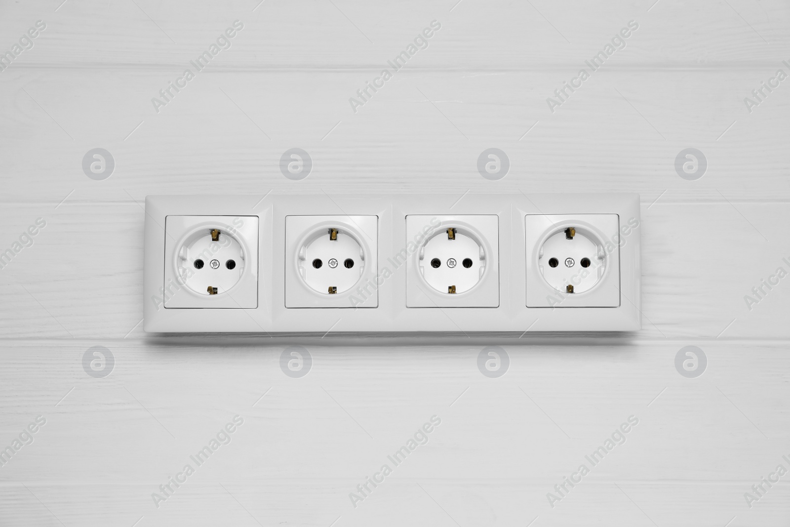 Photo of Modern plastic power socket on white wooden table, top view