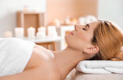 Photo of Beautiful woman with silky skin after face mask relaxing in spa salon