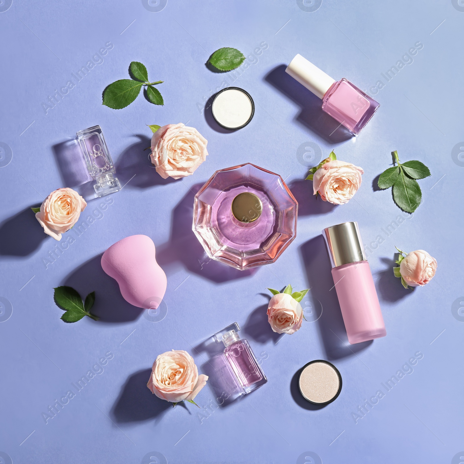 Photo of Flat lay composition with bottles of perfume, cosmetics and roses on color background