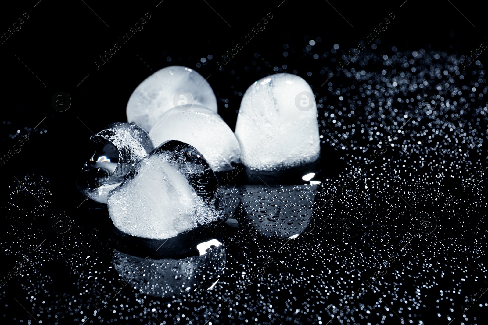 Photo of Melting ice cubes on black background. Space for text