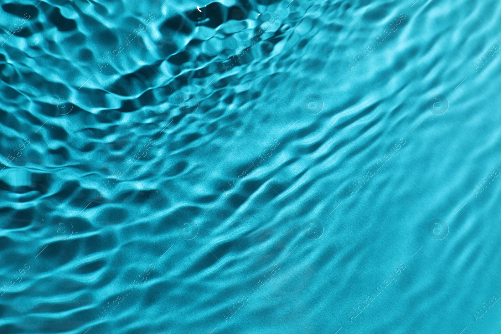 Photo of Rippled surface of clear water on light blue background, top view