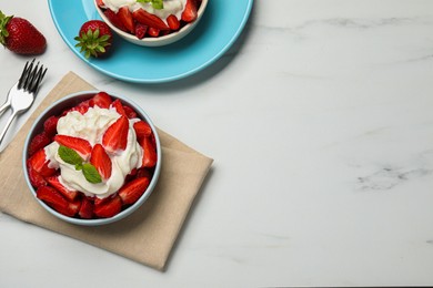 Photo of Delicious strawberries with whipped cream served on white marble table, flat lay. Space for text