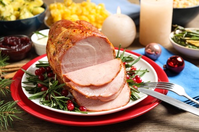 Delicious Christmas ham served with garnish on wooden table