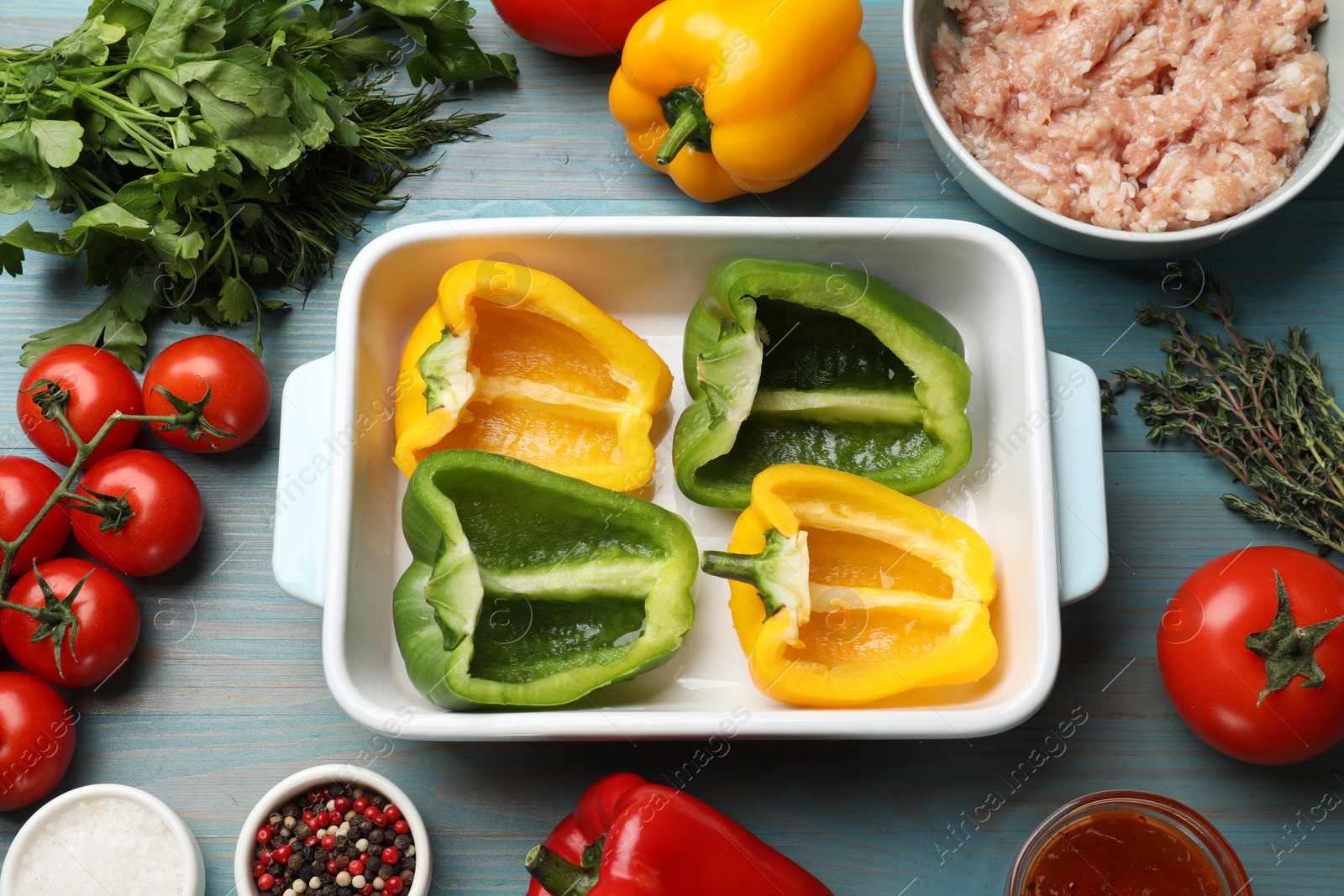 Photo of Making stuffed peppers. Vegetables and ground meat on light blue wooden table, flat lay