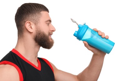 Young man with muscular body holding shaker of protein on white background