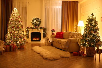 Photo of Festive living room interior with Christmas trees and fireplace